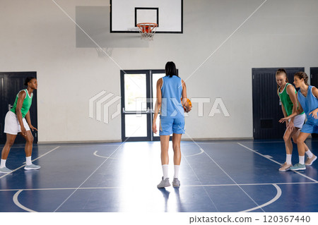 Playing basketball, female athletes practicing on indoor court, preparing for game Playing basketball, female athletes practicing on indoor court, preparing for game 120367440