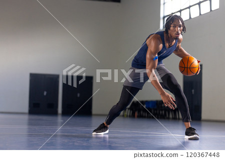 Dribbling basketball, african american man on indoor court, focusing on training, copy space Dribbling basketball, african american man on indoor court, focusing on training, copy space 120367448