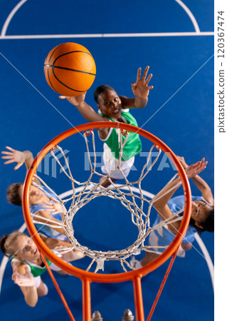 Playing basketball, girl in green jersey jumping to score basket Playing basketball, girl in green jersey jumping to score basket 120367474