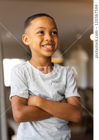 Smiling boy standing confidently at home with arms crossed 120367504
