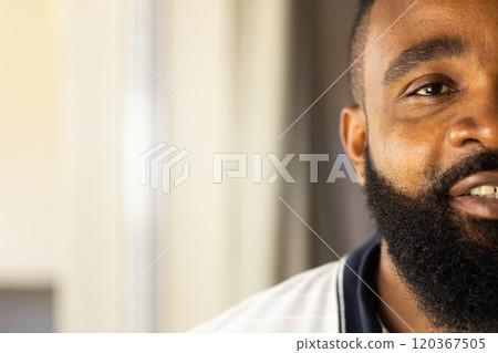 Smiling African American man with beard looking at camera, close-up portrait indoors, copy space 120367505