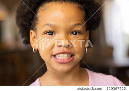 Smiling girl with earrings looking at camera, close-up portrait at home 120367522