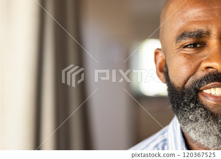 Smiling african american senior man with beard in home, copy space 120367525