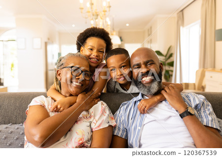 Smiling family sitting on couch, grandparents hugging grandchildren at home Smiling family sitting on couch, grandparents hugging grandchildren at home 120367539