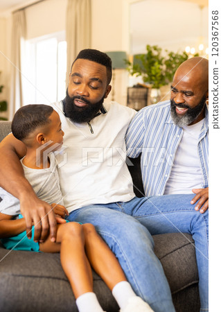 Sitting on couch, family bonding and smiling, enjoying quality time together 120367568