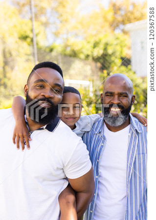 Smiling family, child hugging father and grandfather, enjoying outdoor time together 120367588