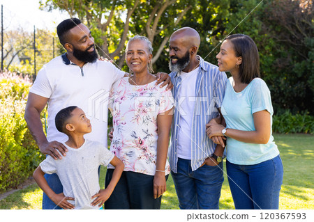 Smiling family standing together in garden, enjoying quality time outdoors Smiling family standing together in garden, enjoying quality time outdoors 120367593