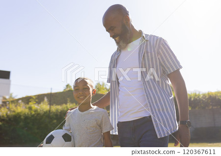 Grandfather and grandson bonding, holding soccer ball, enjoying outdoor time together 120367611