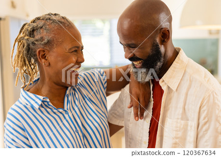 Embracing and laughing together, smiling couple enjoying each other's company at home Embracing and laughing together, smiling couple enjoying each other's company at home 120367634