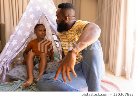 Playing in tent teepee, father and son bonding at home, enjoying quality time Playing in tent teepee, father and son bonding at home, enjoying quality time 120367652