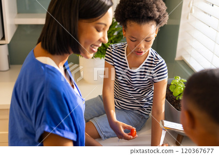 Mother and children in kitchen preparing healthy meal with fresh vegetables Mother and children in kitchen preparing healthy meal with fresh vegetables 120367677