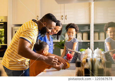 Washing vegetables in kitchen, family enjoying time together, smiling and bonding 120367678