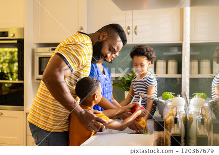 Family washing vegetables together in kitchen, bonding and preparing meal 120367679