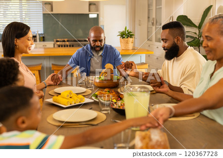 Holding hands, multigenerational family praying before meal at home dining table Holding hands, multigenerational family praying before meal at home dining table 120367728