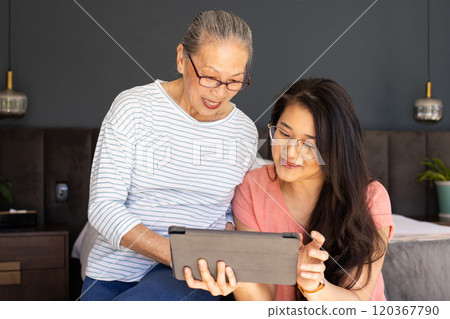 Using tablet, asian grandmother and granddaughter enjoying time together indoors Using tablet, asian grandmother and granddaughter enjoying time together indoors 120367790
