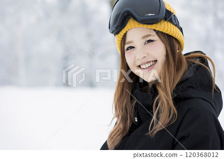 Snowboard girls standing with a smile at a snowy ski resort 120368012