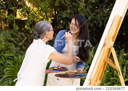 Painting on canvas, Asian granddaughter and grandmother enjoying outdoor art activity together Painting on canvas, Asian granddaughter and grandmother enjoying outdoor art activity together 120368677