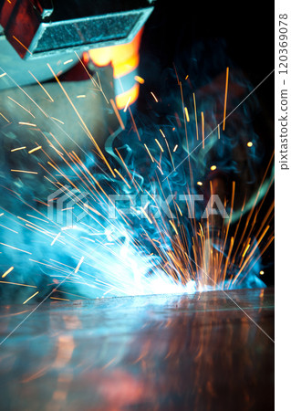 Welder uses torch to make sparks during manufacture of metal equipment, industrial professional worker Welder uses torch to make sparks during manufacture of metal equipment, industrial professional worker 120369078