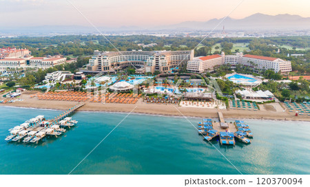 Expansive resort-lined beach with clear waters and scenic piers inviting travelers to relax. 120370094