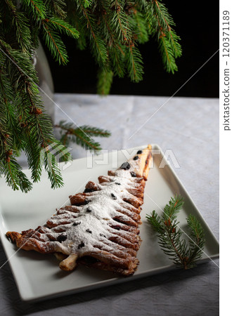 A white plate with a dessert shaped like a Christmas tree 120371189