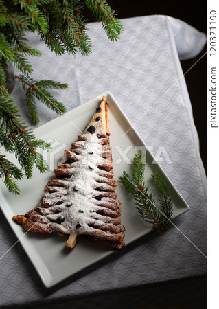 A white plate with a dessert shaped like a Christmas tree 120371190