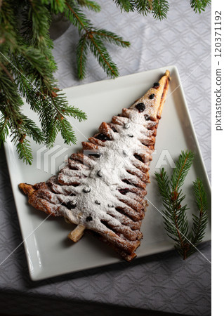A white plate with a dessert shaped like a Christmas tree 120371192