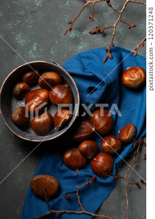 A bowl with edible chestnuts stands on a blue cloth A bowl with edible chestnuts stands on a blue cloth 120371248