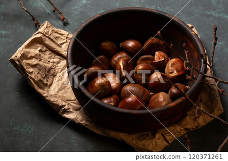 Edible chestnuts in a wooden bowl Edible chestnuts in a wooden bowl 120371261