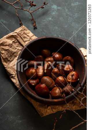 Edible chestnuts in a wooden bowl Edible chestnuts in a wooden bowl 120371263