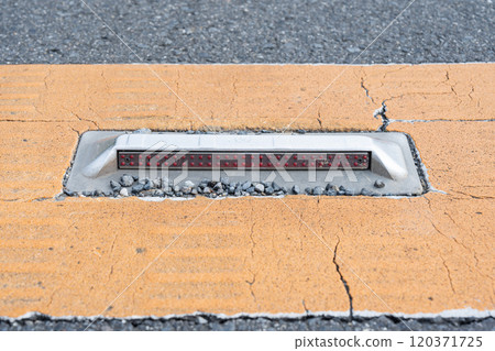 Road reflectors and cracked pavement Road reflectors and cracked pavement 120371725