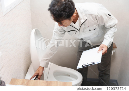 Plumber inspecting a toilet Plumber inspecting a toilet 120372714