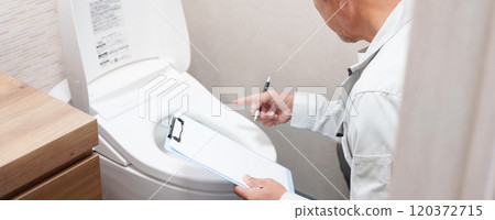 Plumber inspecting a toilet 120372715