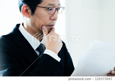 Businessman looking at materials Businessman looking at materials 120373047