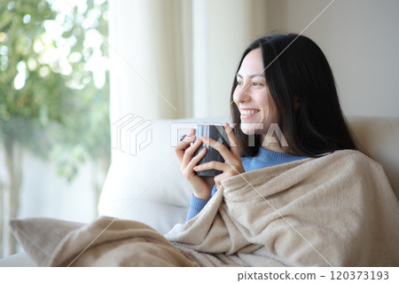 Happy asian woman drinking covered with blanket in winter 120373193
