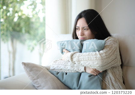 Sad asian woman complaining hugging pillow at home Sad asian woman complaining hugging pillow at home 120373220