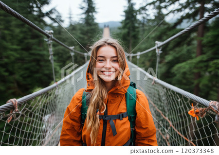 Girl with backpack crossing a suspension bridge 120373348