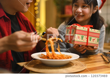 Cropped shot romantic couple enjoying pasta and exchanging gifts in a kitchen Cropped shot romantic couple enjoying pasta and exchanging gifts in a kitchen 120373469