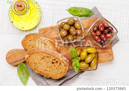 An assortment of various olives presented in a bowl, showcasing different colors, textures, and flavors An assortment of various olives presented in a bowl, showcasing different colors, textures, and flavors 120373665