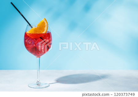 A cocktail arranged on a table against a light blue background 120373749