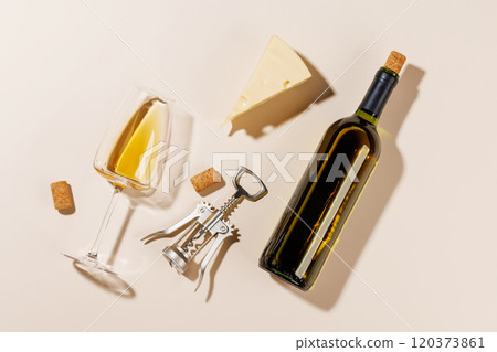 Wine glass, bottle alongside a corkscrew and several corks 120373861