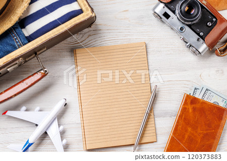 A travel bag with clothes, sun hat, flip flops, and a camera A travel bag with clothes, sun hat, flip flops, and a camera 120373883