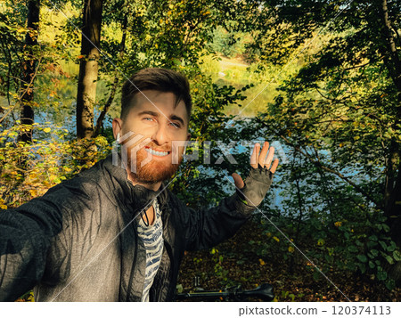 Selfie of a cyclist in the forest. Man smiling while riding his bicycle outdoors. Concept of safety while cycling in the rural areas Selfie of a cyclist in the forest. Man smiling while riding his bicycle outdoors. Concept of safety while cycling in the rural areas 120374113
