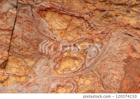 Giant Causeway basalt rock texture with red hues formed by volcanic and iron rich processes Giant Causeway basalt rock texture with red hues formed by volcanic and iron rich processes 120374210