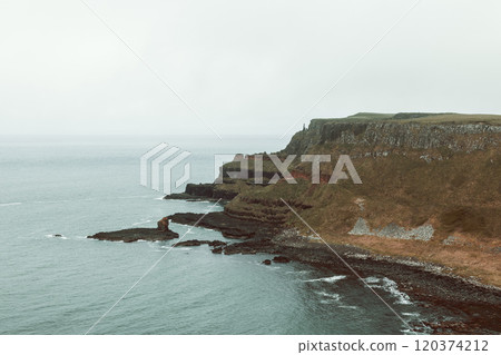 Rugged cliffs and calm ocean at Giant Causeway with subtle nostalgic vintage tones Rugged cliffs and calm ocean at Giant Causeway with subtle nostalgic vintage tones 120374212