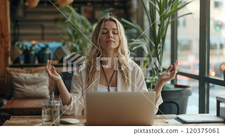 A woman meditates at her desk with closed eyes, practicing mindfulness in a bright, plant-filled workspace, surrounded by a laptop, glass of water, and natural light A woman meditates at her desk with closed eyes, practicing mindfulness in a bright, plant-filled workspace, surrounded by a laptop, glass of water, and natural light 120375061