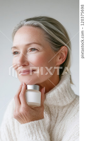 Elegant mature model posing with skincare product in studio close-up Elegant mature model posing with skincare product in studio close-up 120375698