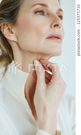 Elegant portrait of mature woman applying skincare for anti-aging beauty concept 120375710