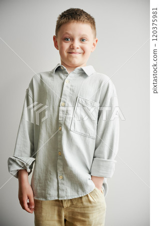 Portrait of happy boy in casual clothes keeping hand in pocket. Adorable boy smiling to camera. Stylish kid posing on white background. Portrait of happy boy in casual clothes keeping hand in pocket. Adorable boy smiling to camera. Stylish kid posing on white background. 120375981