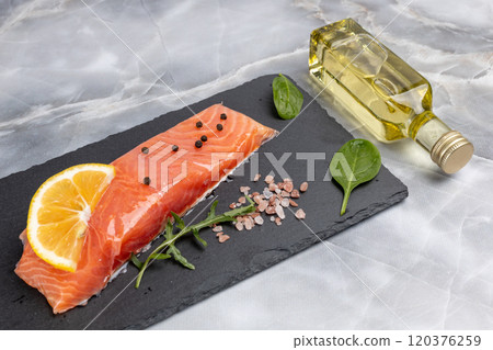 Fillet of raw salmon fish with arugula, basil and lemon on the cutting board Fillet of raw salmon fish with arugula, basil and lemon on the cutting board 120376259