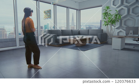 Female designer in AR headset arranges stylish apartment with 3D furniture Female designer in AR headset arranges stylish apartment with 3D furniture 120376633